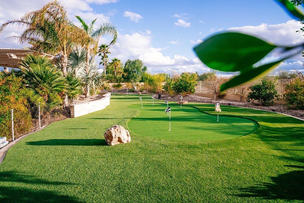 Custom putting green with flags and mature landscaping