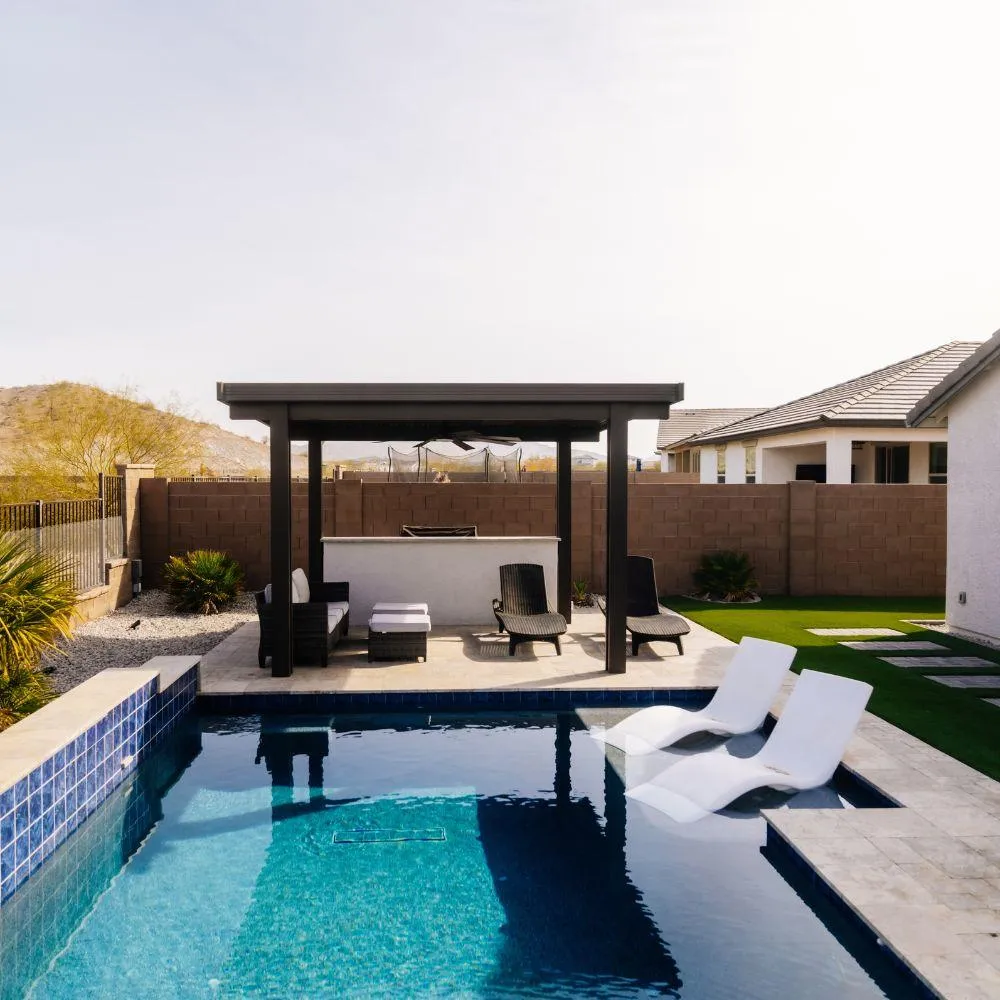 Modern pool with pergola bar and chaise lounges