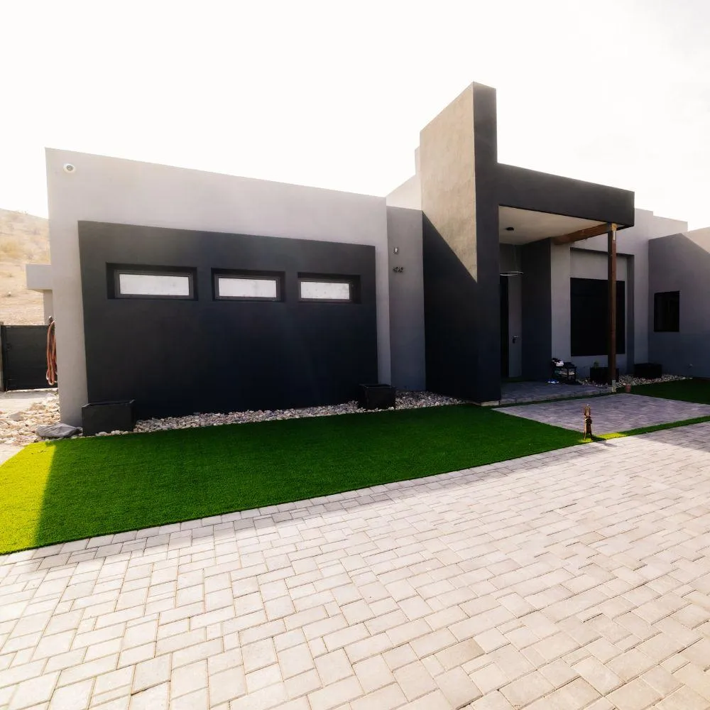 Modern desert home with paver driveway and turf accent