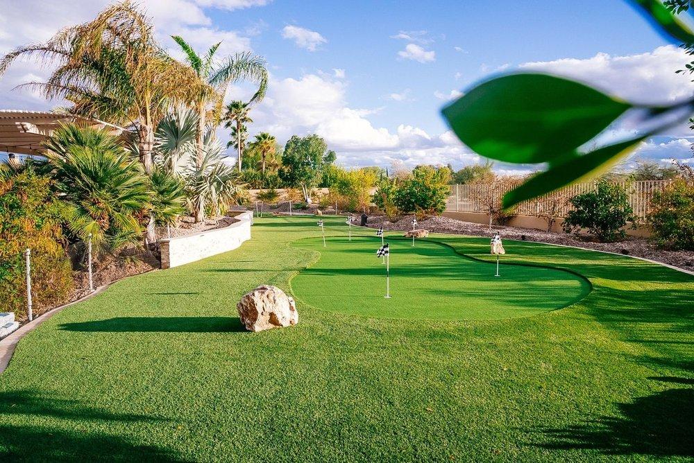 Backyard putting green with flags and rock accents