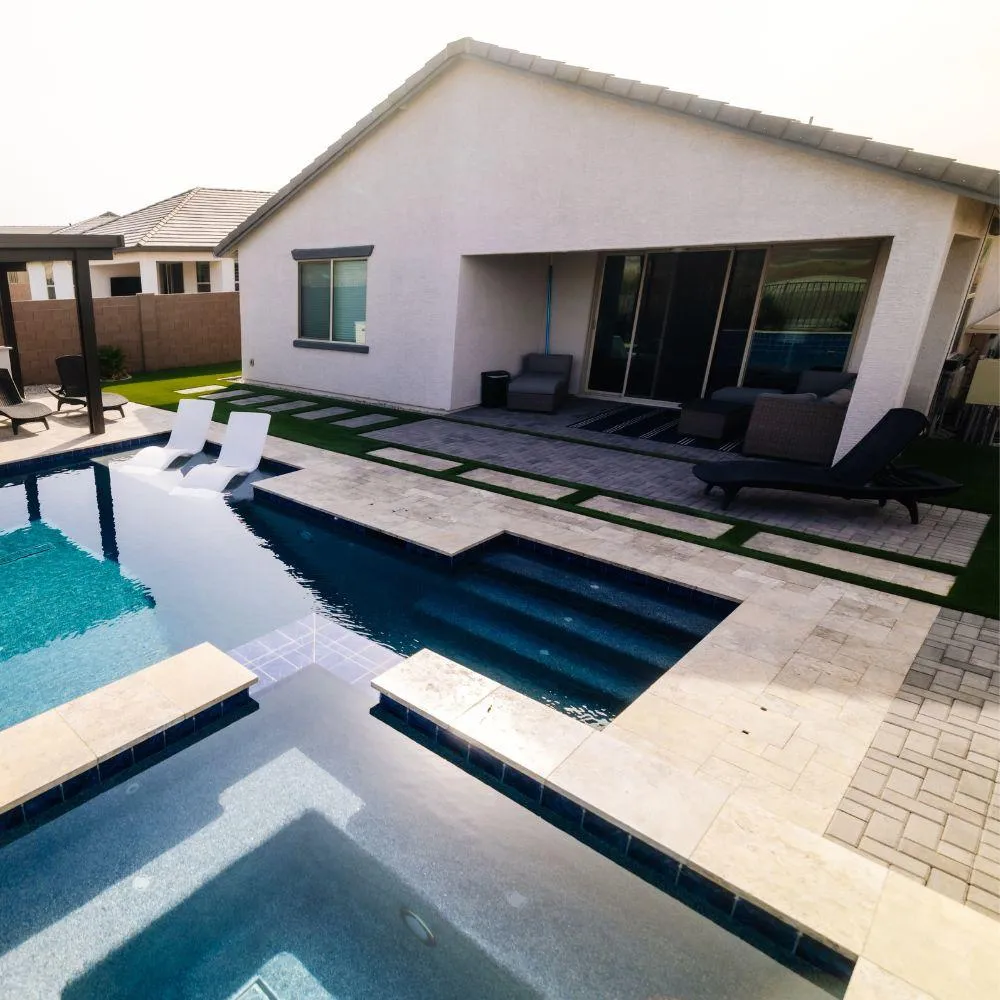 Pool with travertine deck and turf inlay walkway