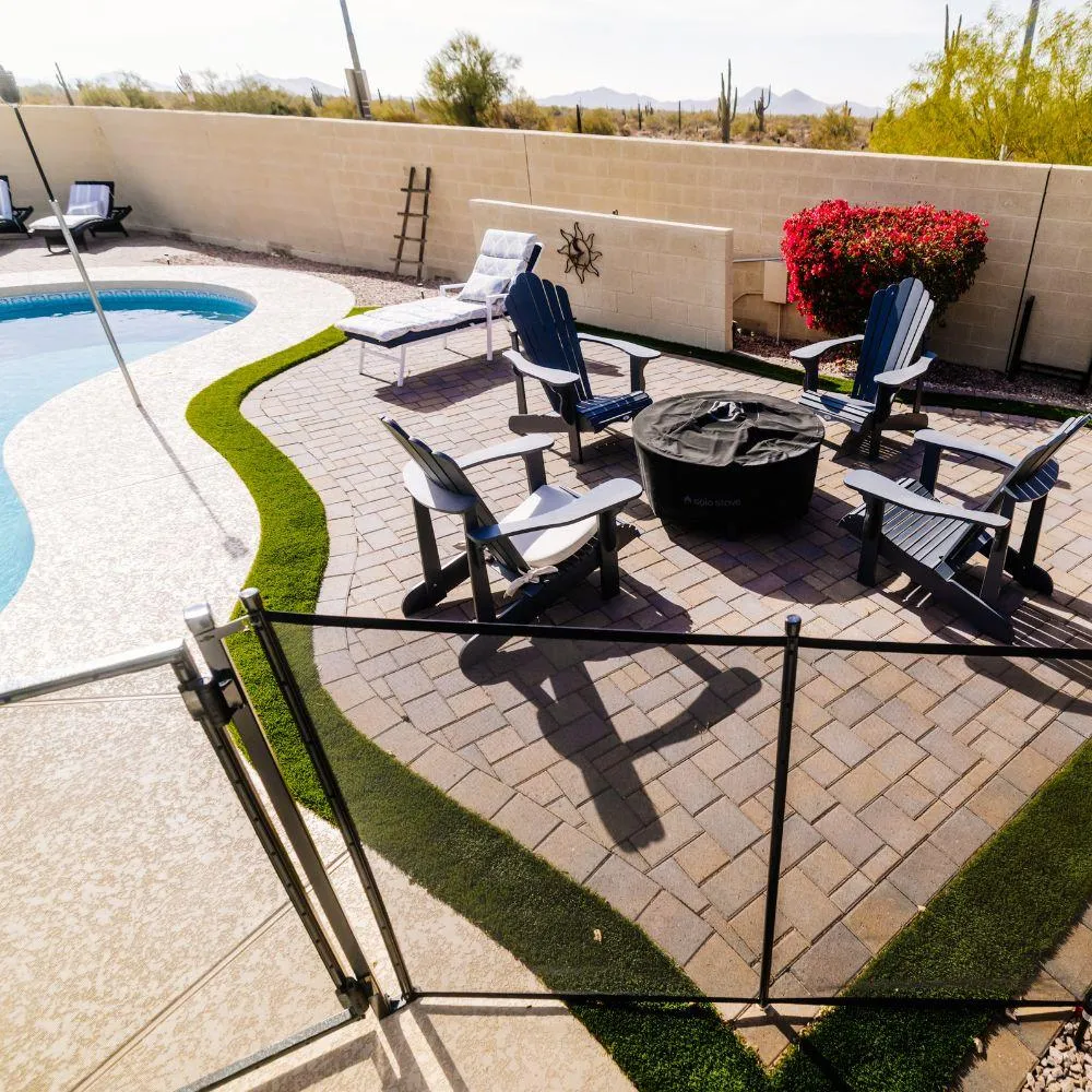 Paver patio with adirondack chairs around fire pit near pool