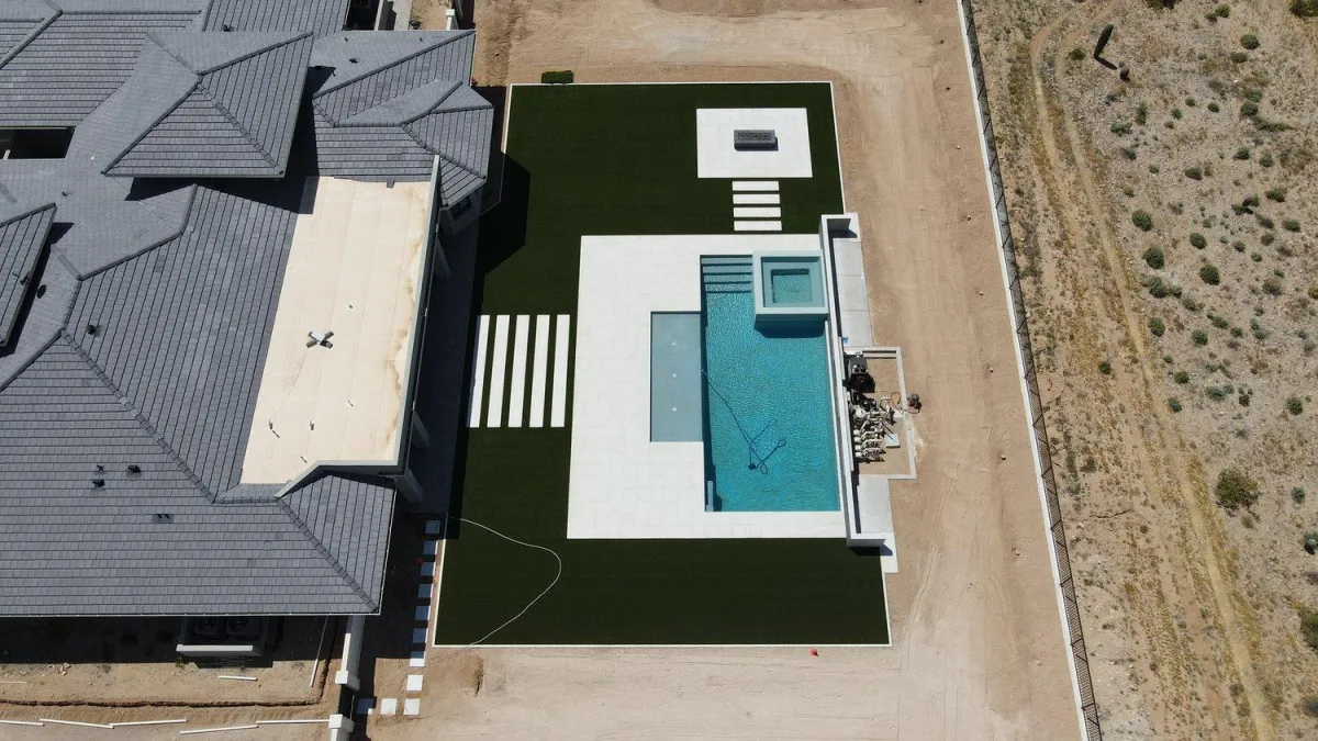 Aerial view of modern pool, spa, and turf lawn