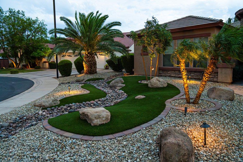Front yard turf design with river rock and boulders