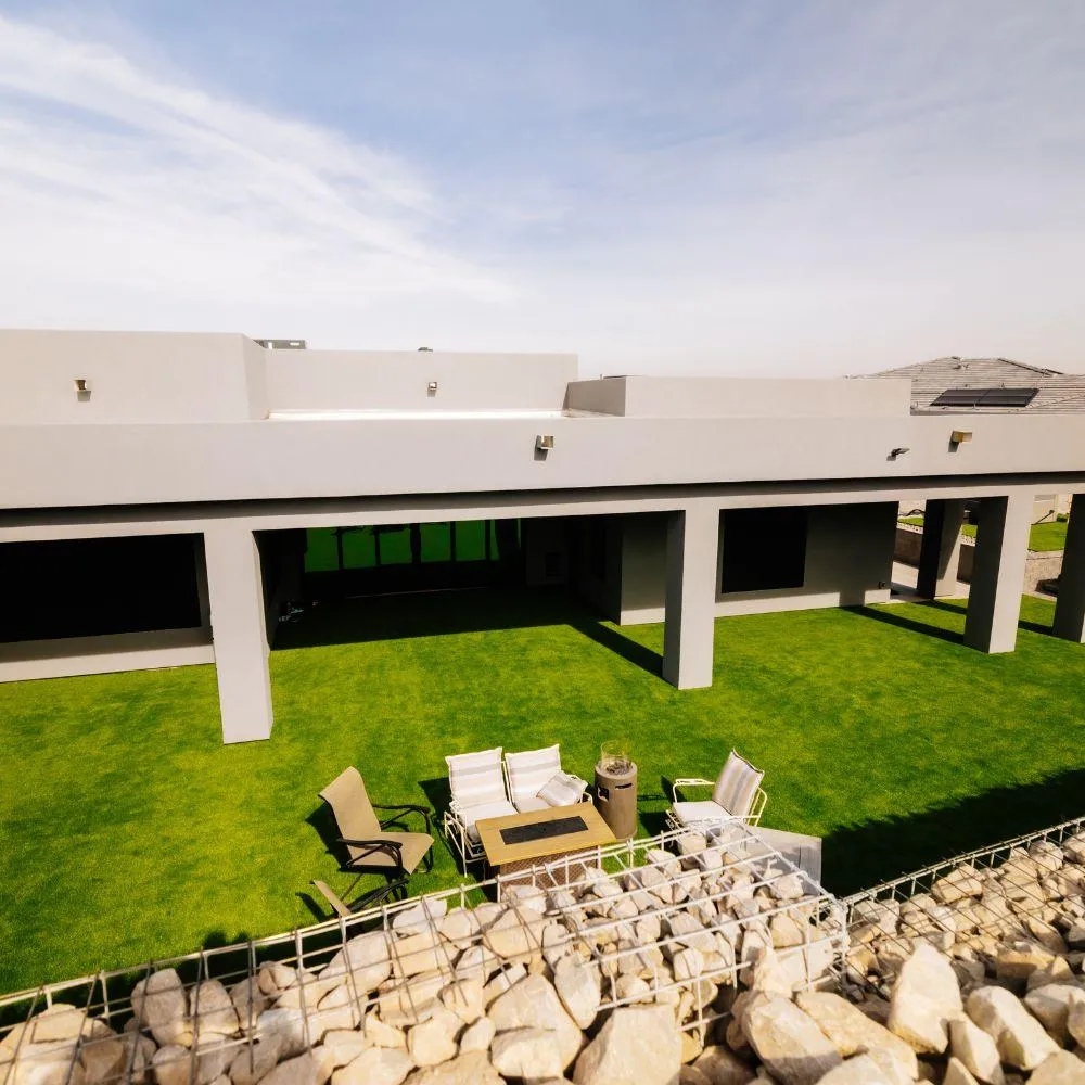 Modern home with covered patio and gabion wall turf yard